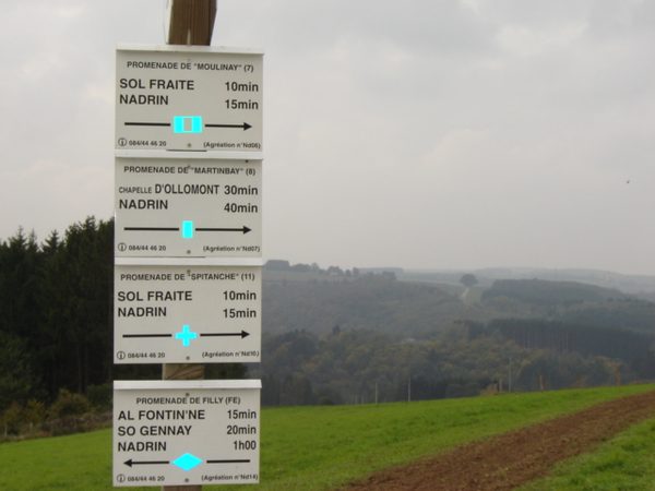 Panneau indiquant les distances de randonnée vers Nadrin et Filly.