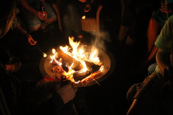 Les flammes du feu ouvert, avec des gens autour.
