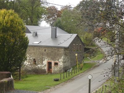 La maison vue depuis la route qui traverse le hameau.