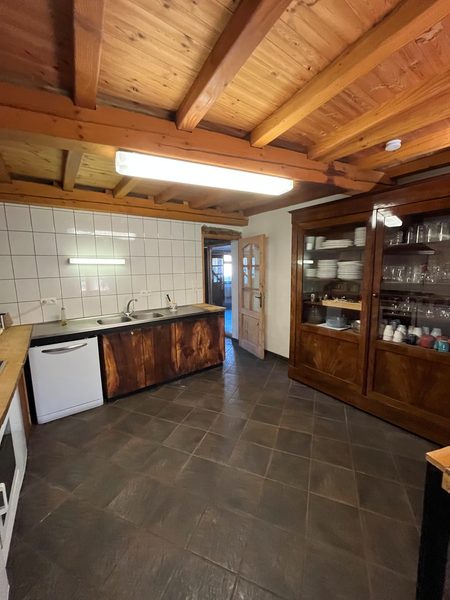 La cuisine vue de l'autre côté, avec le lave-vaisselle et la vaisselle.