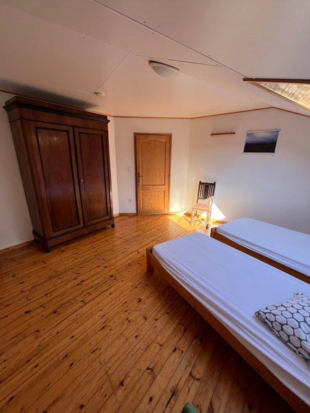 Chambre avec lit double et plancher en bois.