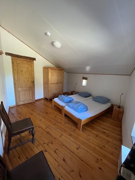 Une chambre avec un lit sous le toit en pente.