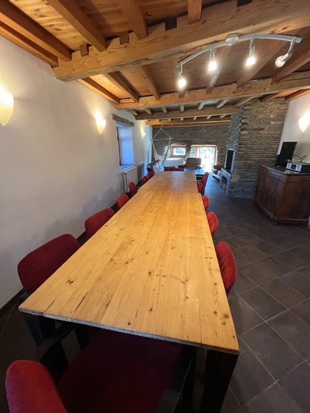 La grande table du séjour, sous le plafond à poutres.