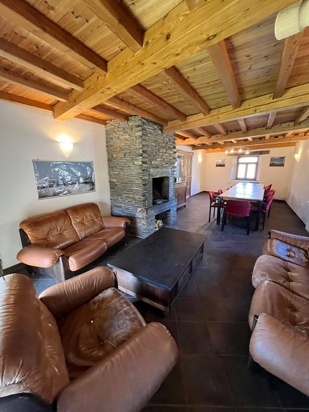 Le séjour avec ses fauteuils en cuir et la longue table en bois.